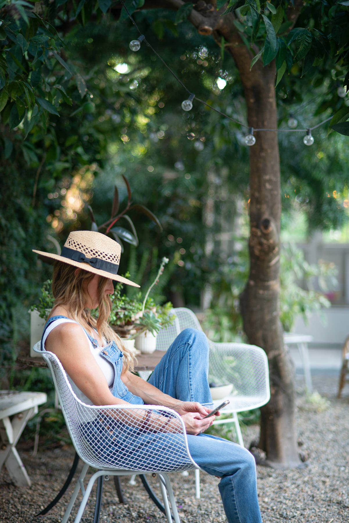Midlife woman sitting in a garden taking a break and learning how to stop perfectionism