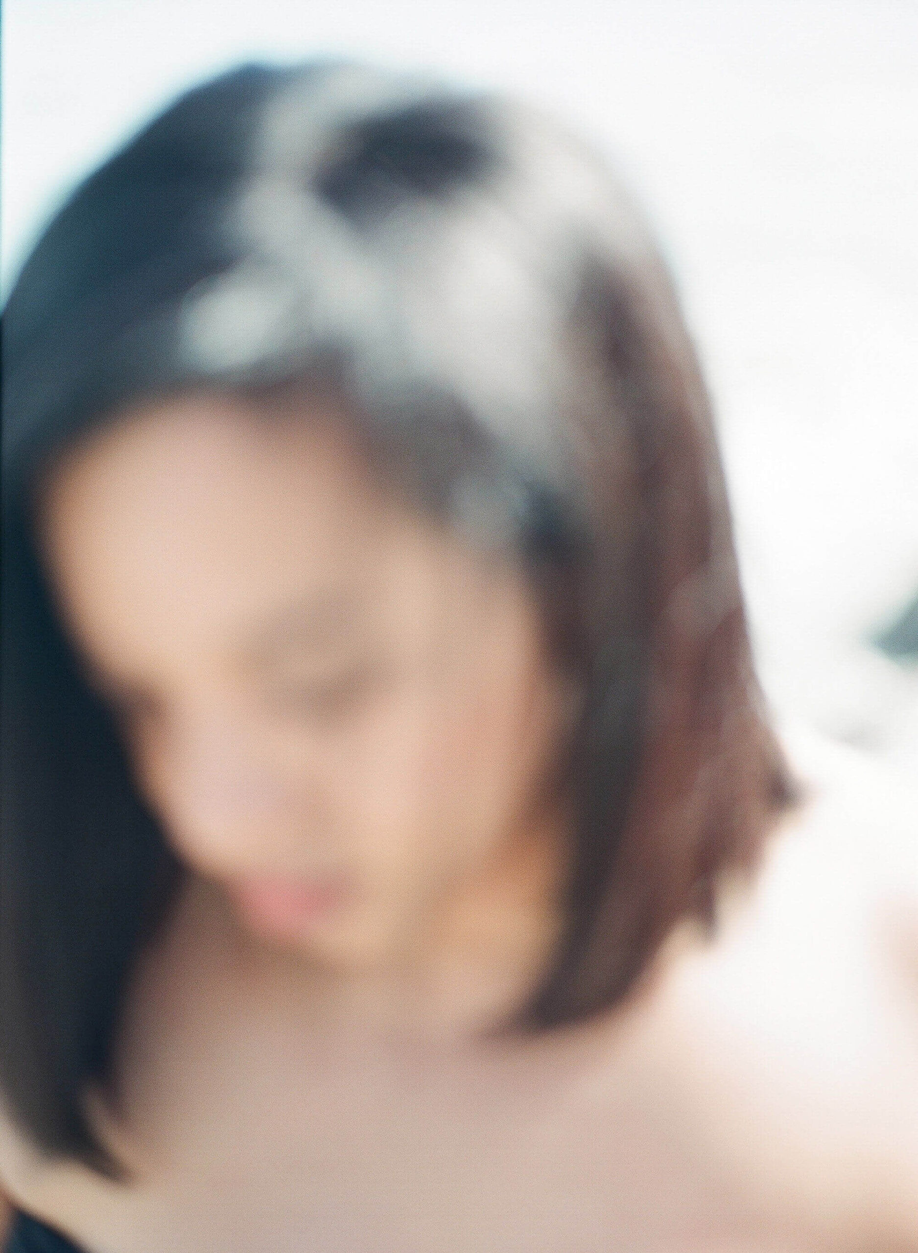Woman with dark bobbed hair, head slightly lowered in a quiet moment of self-awareness
