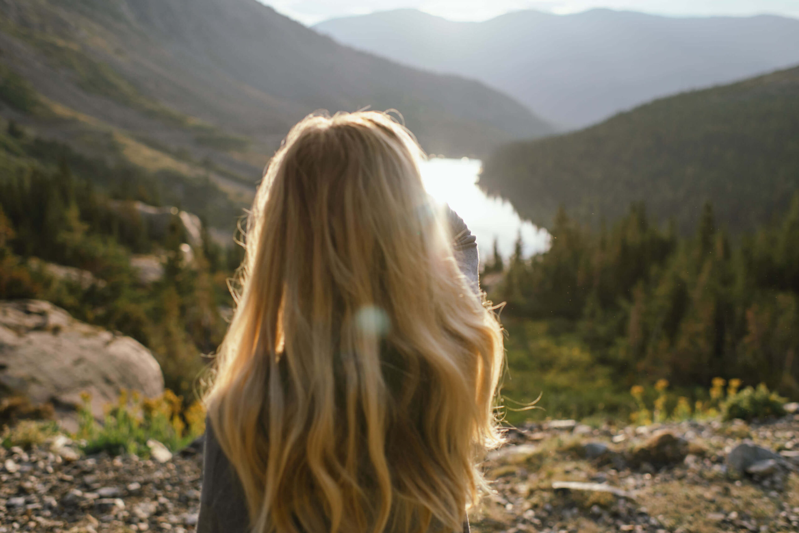 Woman looking over a mountain landscape, illustrating learning to trust yourself and new possibilities.
